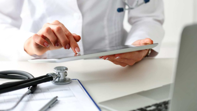 Medicīnas darbinieka rokas pie datora