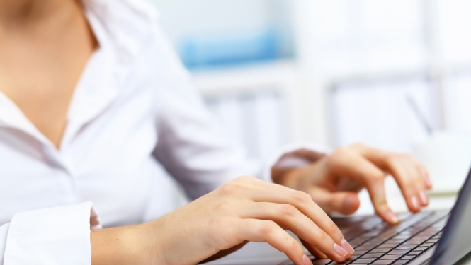 Sievietes rokas un portatīvā datora klaviatūras