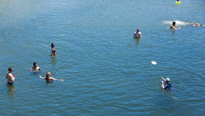 Vairāki peldoši  cilvēki ūdenstilpnē