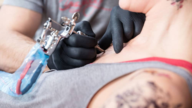 Tetovēšanas ierīce un cilvēka roka