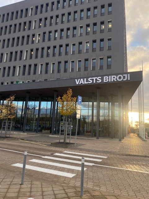 Pelēka ēka ar uzrakstu "Valsts biroji"