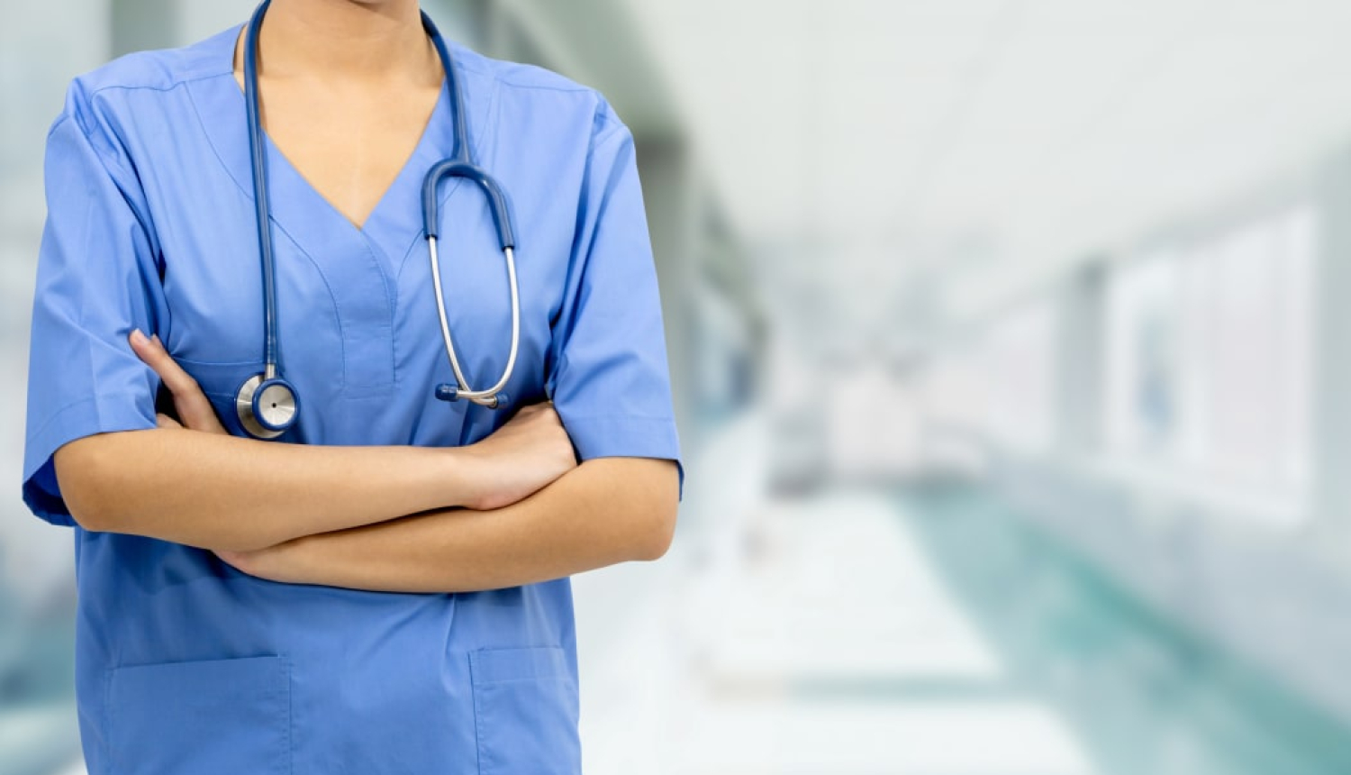 Medicīnas darbinieks gaiši zilā darba apģērbā ap kaklu fonendoskops