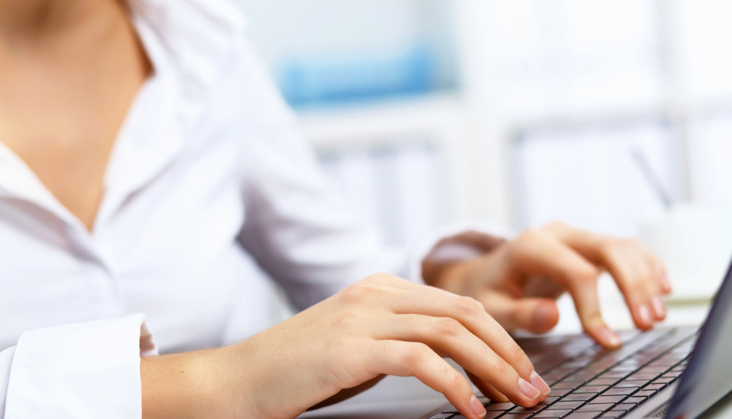 Sievietes rokas un portatīvā datora klaviatūras