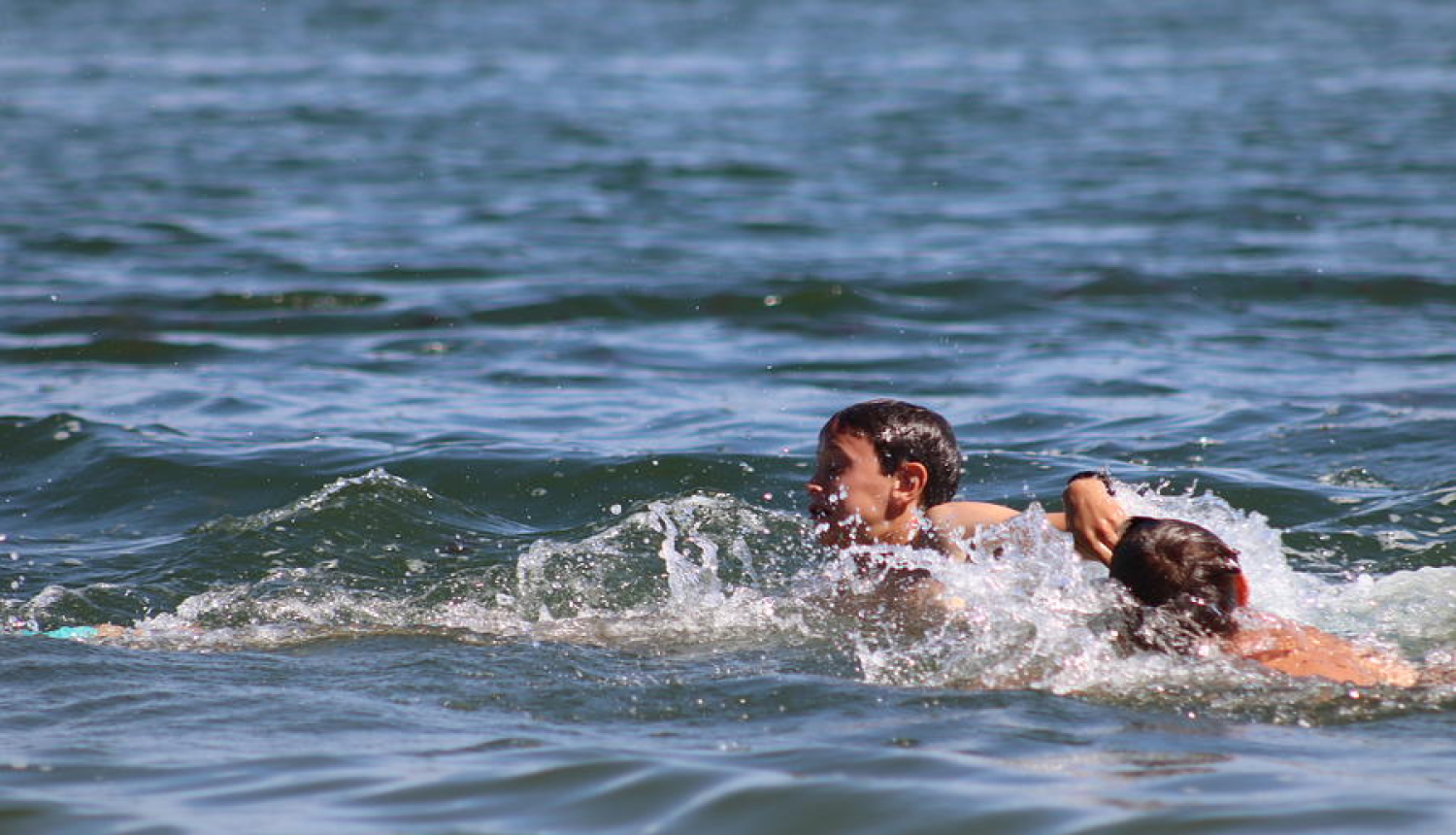 Zils jūras ūdens, ūdenī peld divi cilvēki