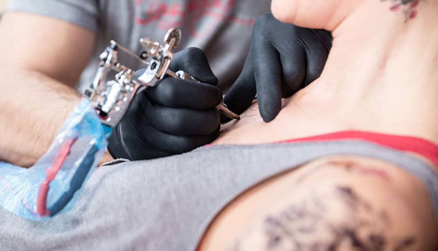 Tetovēšanas ierīce un cilvēka roka